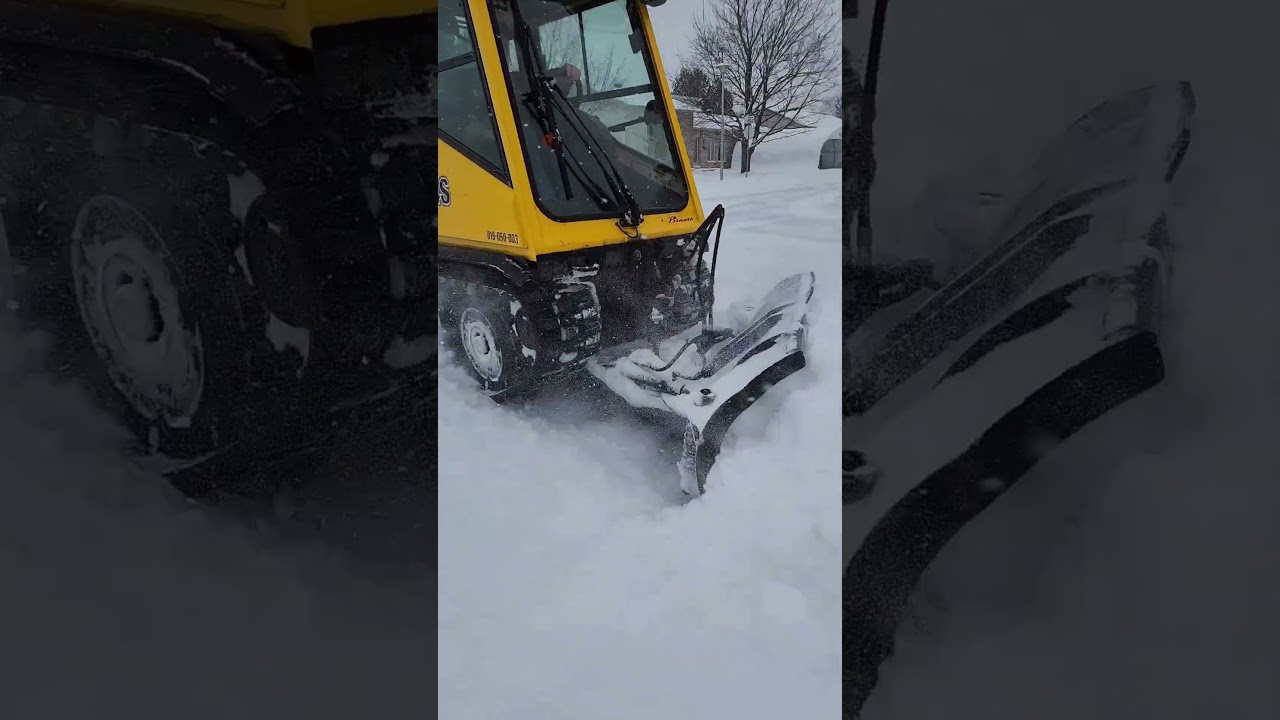 Sidewalk Tractor Removing Snow From Walkway