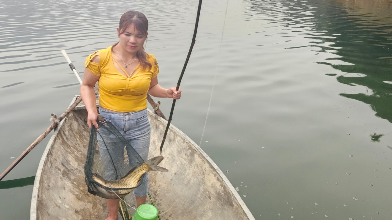 The girl set up several fishing lines by the lake to catch big fish.