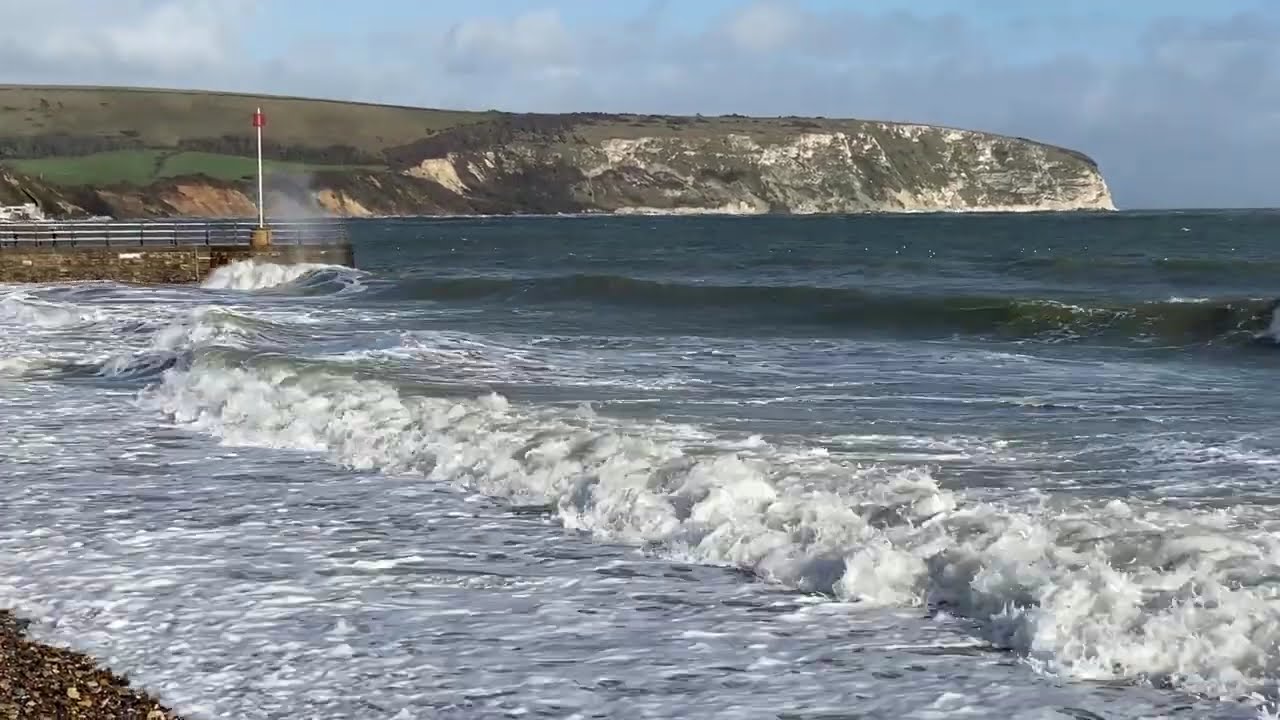 High tide and strong winds causing big waves to break over the sea walls in Swanage Bay today