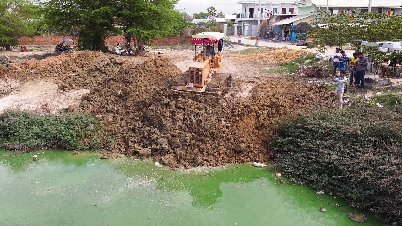 The dozer KOMATSU D31P Machine is Removing a Deep Pond
