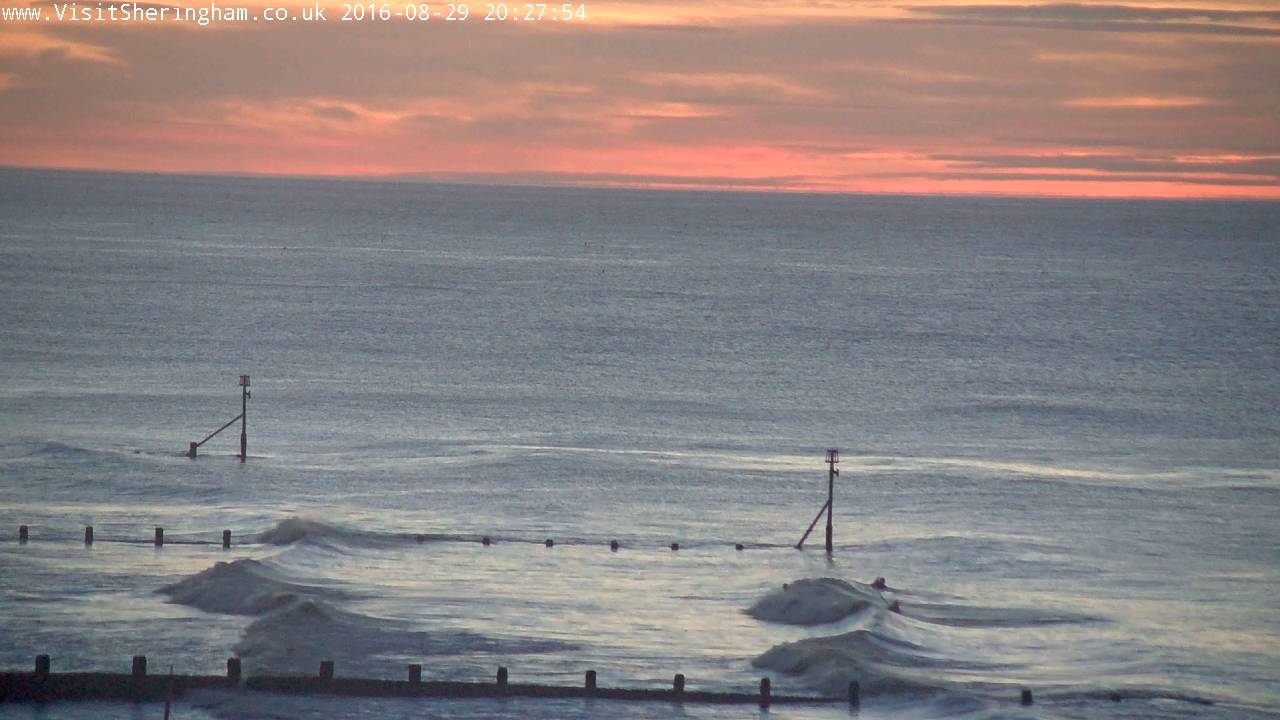 Surfers out at Sunset in Sheringham, Norfolk, UK