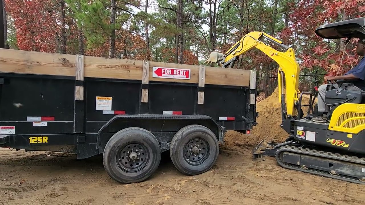 New Holland E17c mini excavator loading dump trailer with fill dirt