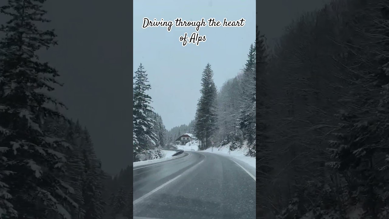 driving during snowfall through the heart of the Alps 