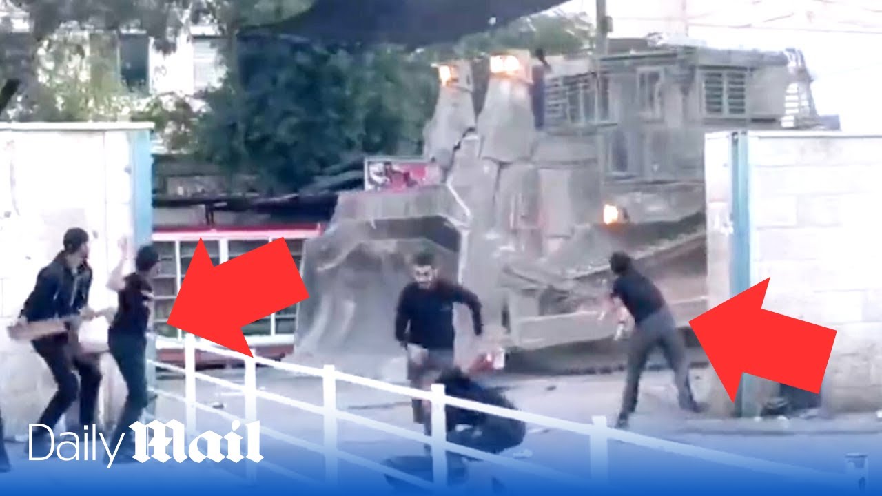 Palestinians throw rocks at heavily armoured Israeli bulldozers in the West Bank