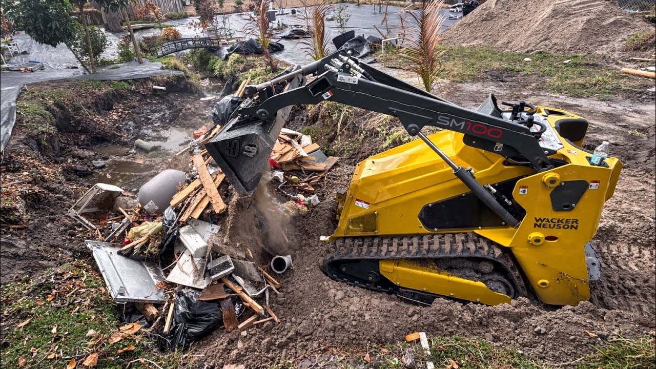 Filling in a old backyard pond with the mini skid ( Wacker Neuson SM100 )