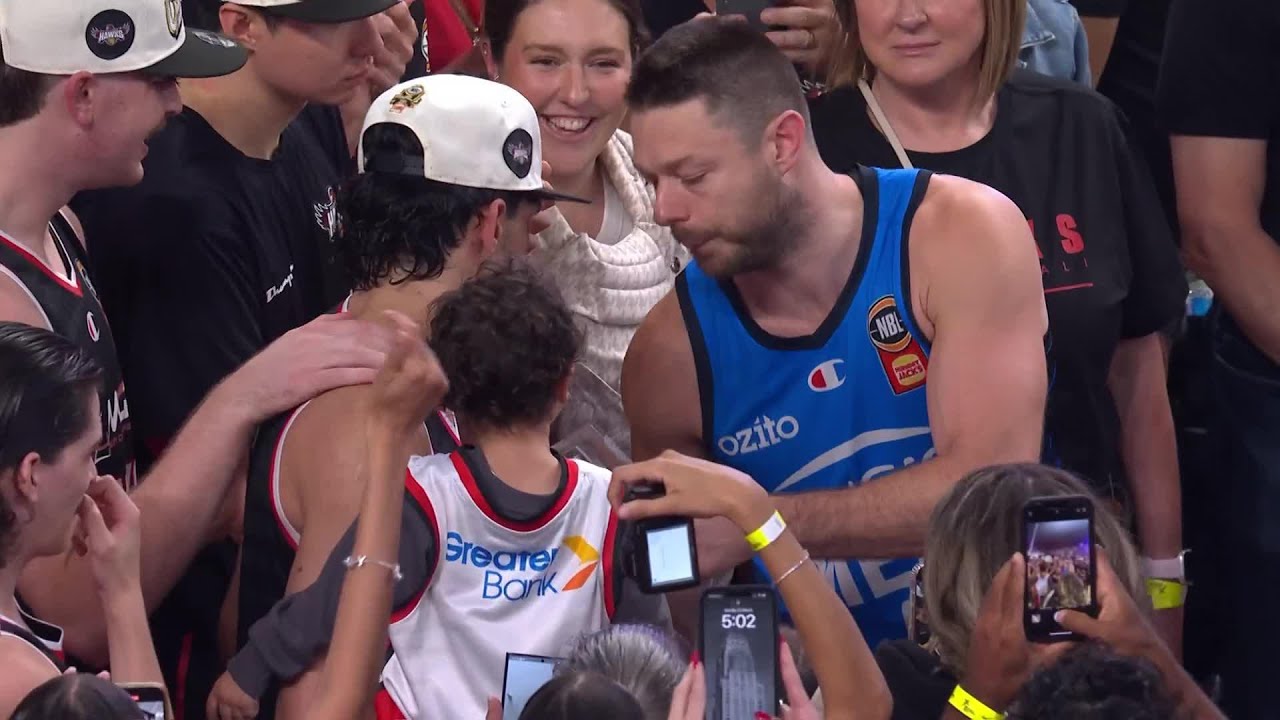 Matthew Dellavedova hands Will Hickey the NBL25 Larry Sengstock Trophy