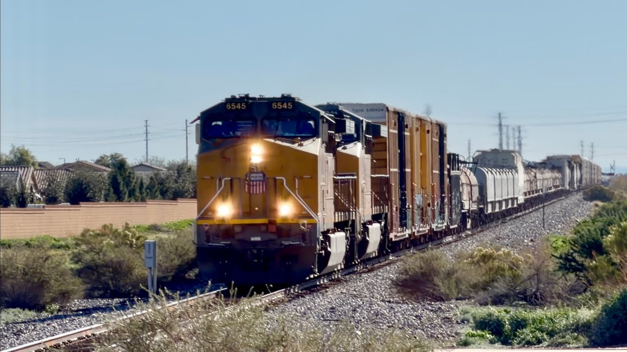 A UP new paint 6545 leads a Phoenix train with lots of steel coil cars at Queen Creek AZ 1-1-26