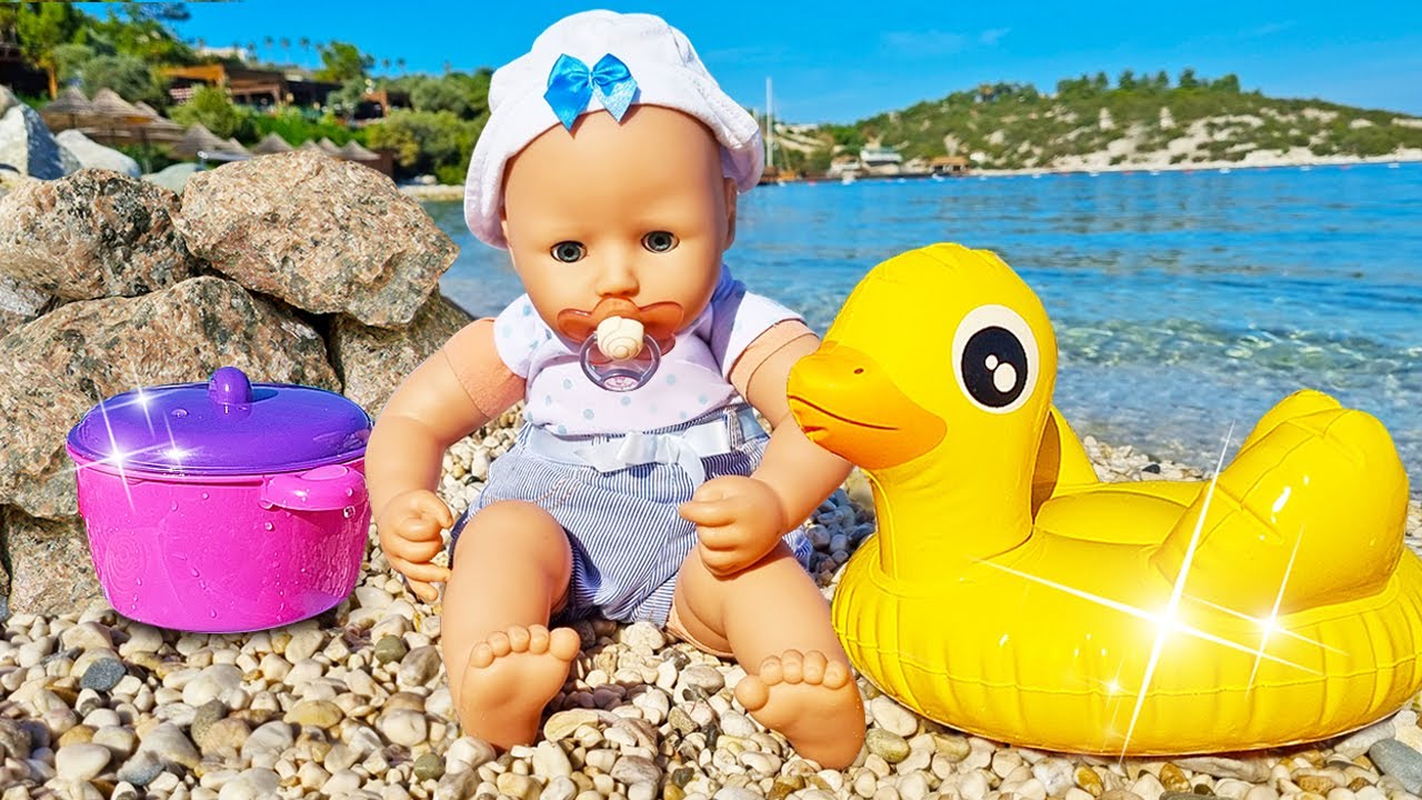 A boneca bebê descobre a praia pela primeira vez e brinca com pato!