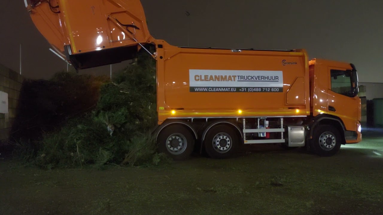 Unloading garbagetruck with Christmas trees - Vuilniswagen vol kerstbomen lossen