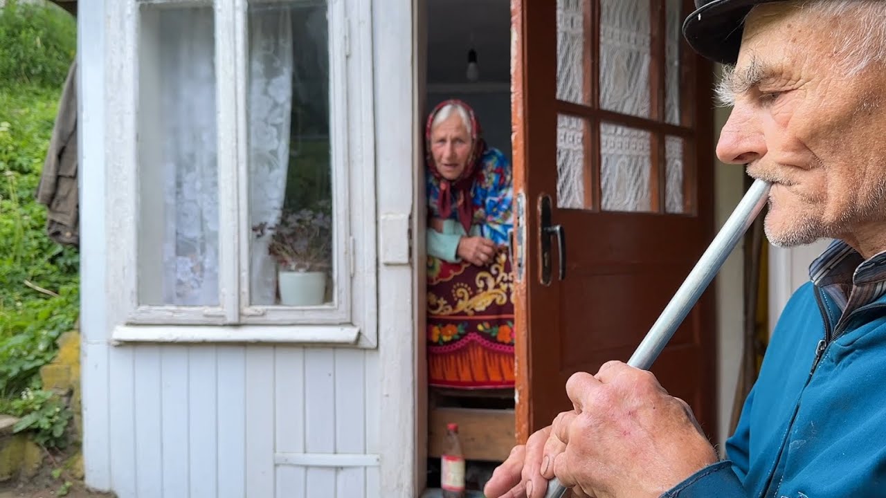 Happy old age of an elderly couple of shepherd in a mountain village far from civilization