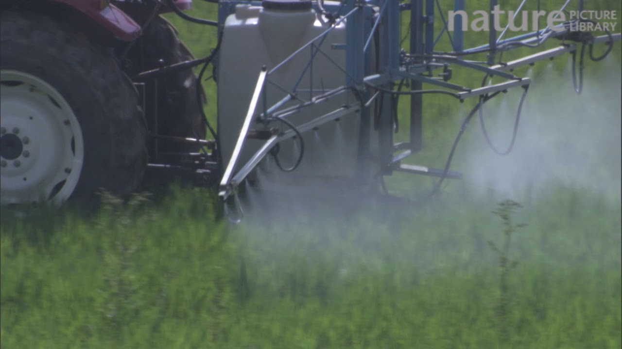 Close-up of a tractor spraying pesticide or fertiliser on a field, France