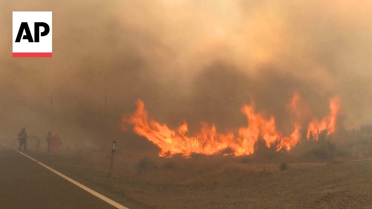 Firefighters battle a human-caused wildfire as it rapidly approaches Reno