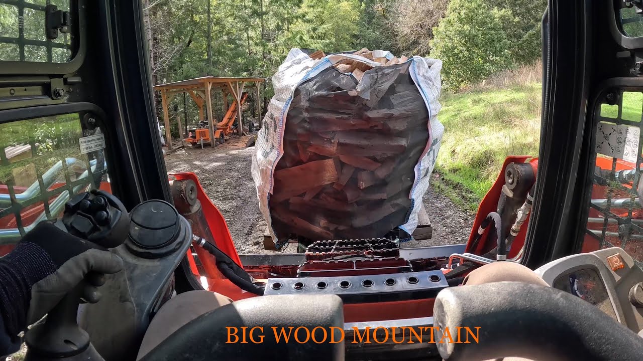 Kubota SVL65-2 flipping Log Lift bags of firewood into the trailer for delivery POV