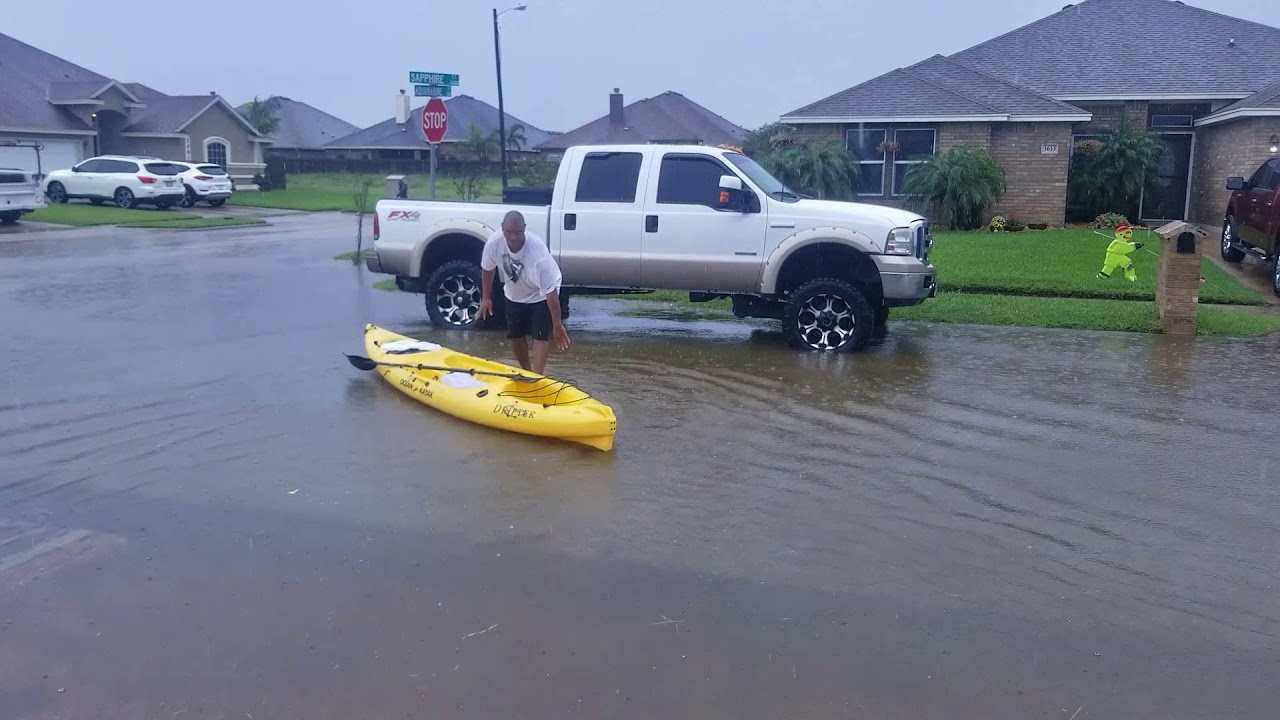 Mark in kayak in front of house flooded street