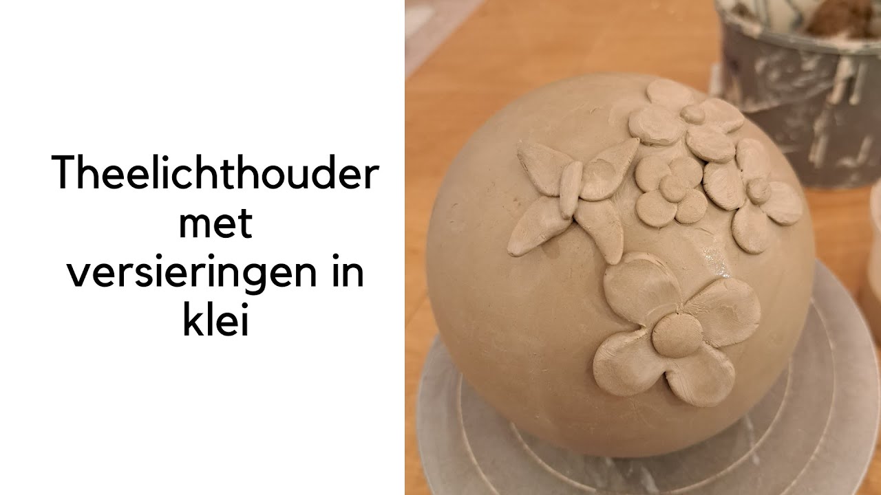 Een theelichthouder met versieringen in klei