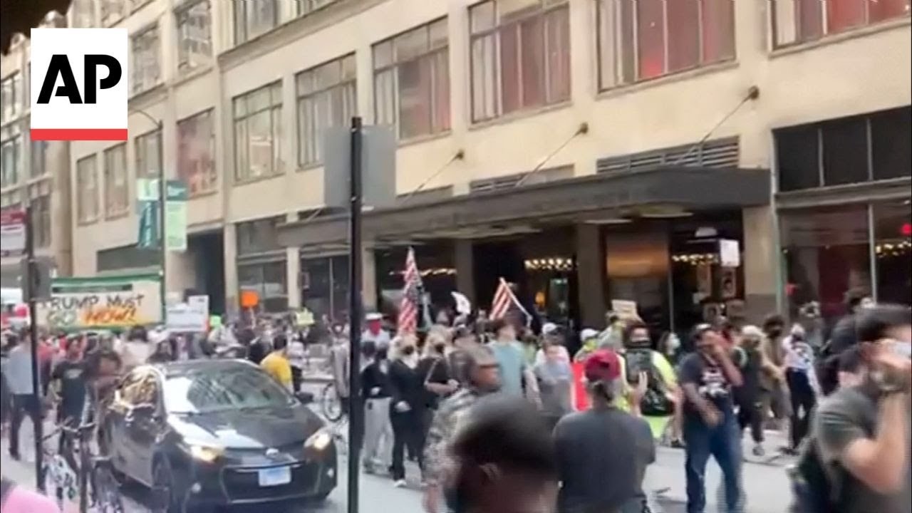 Car moves through a crowd in Chicago protesting ICE raids