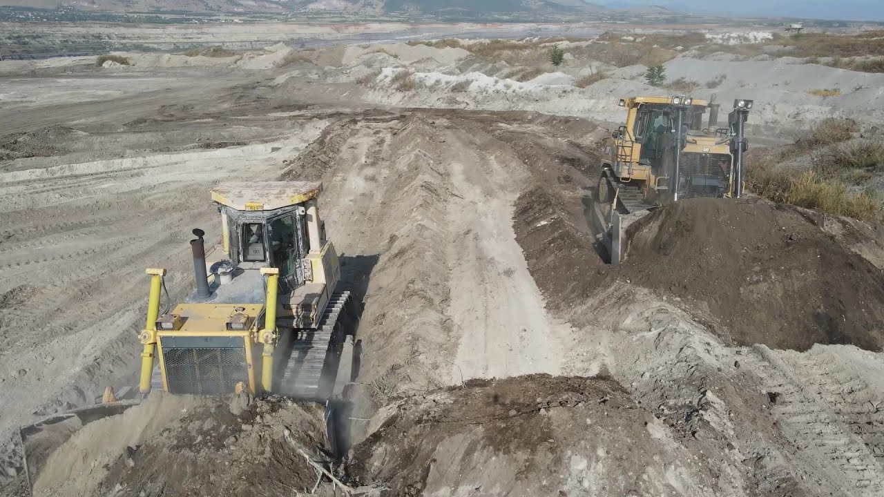 Caterpillar D9T And Komatsu D275 Bulldozers Pushing Soil On Huge Mining Area