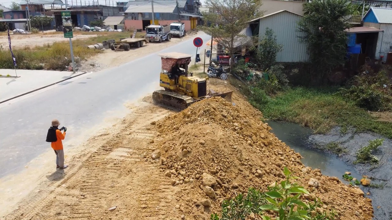 Best Skilled KOMAT’SU Dozer Operator And 6-Wheel Dump Trucks Drivers Working Together To Move Soil.