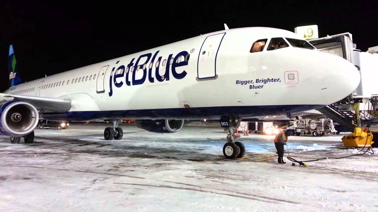 JetBlue Airways A321 Airbus arriving at Terminal 5 JFK at night with snow on the ground