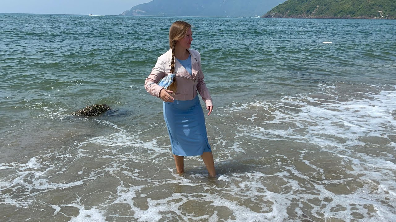 Light blue tight-fitting dress, pink jacket. Lulu gets wet in the sea and gets dirty in the sand.