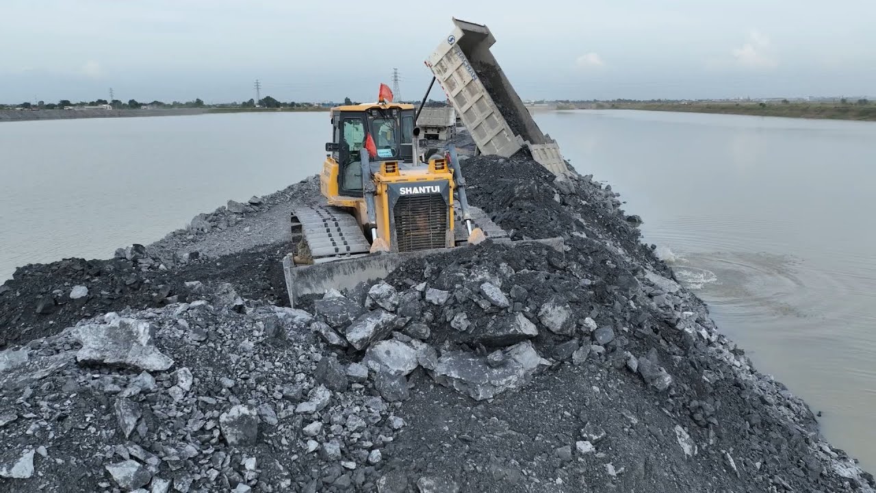 Construction of a road over water, quarrying and filling , dozers SHANTUI please stone and Truck 25T