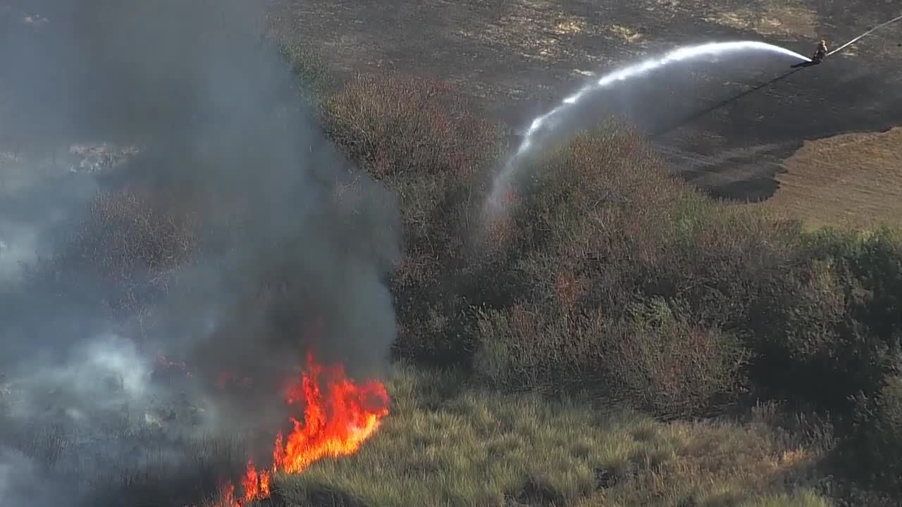 Brush fire burns near homes in Orange County subdivision