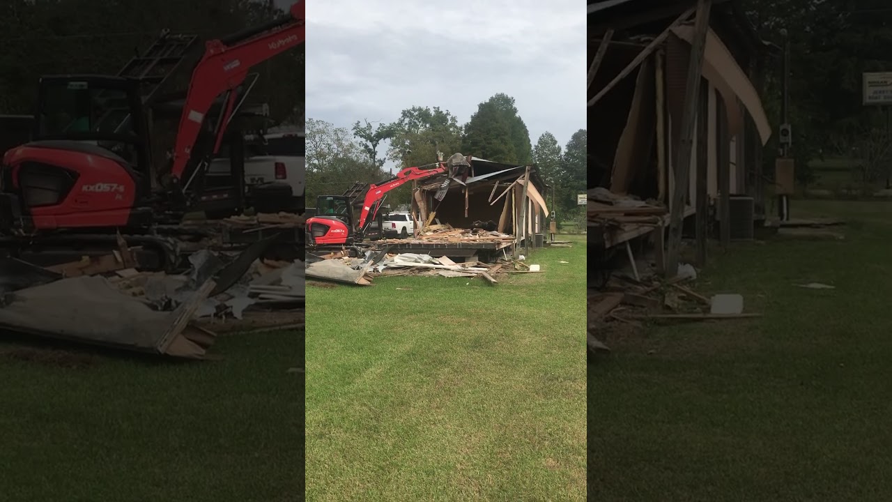 Mobile home being torn down by a mini excavator.