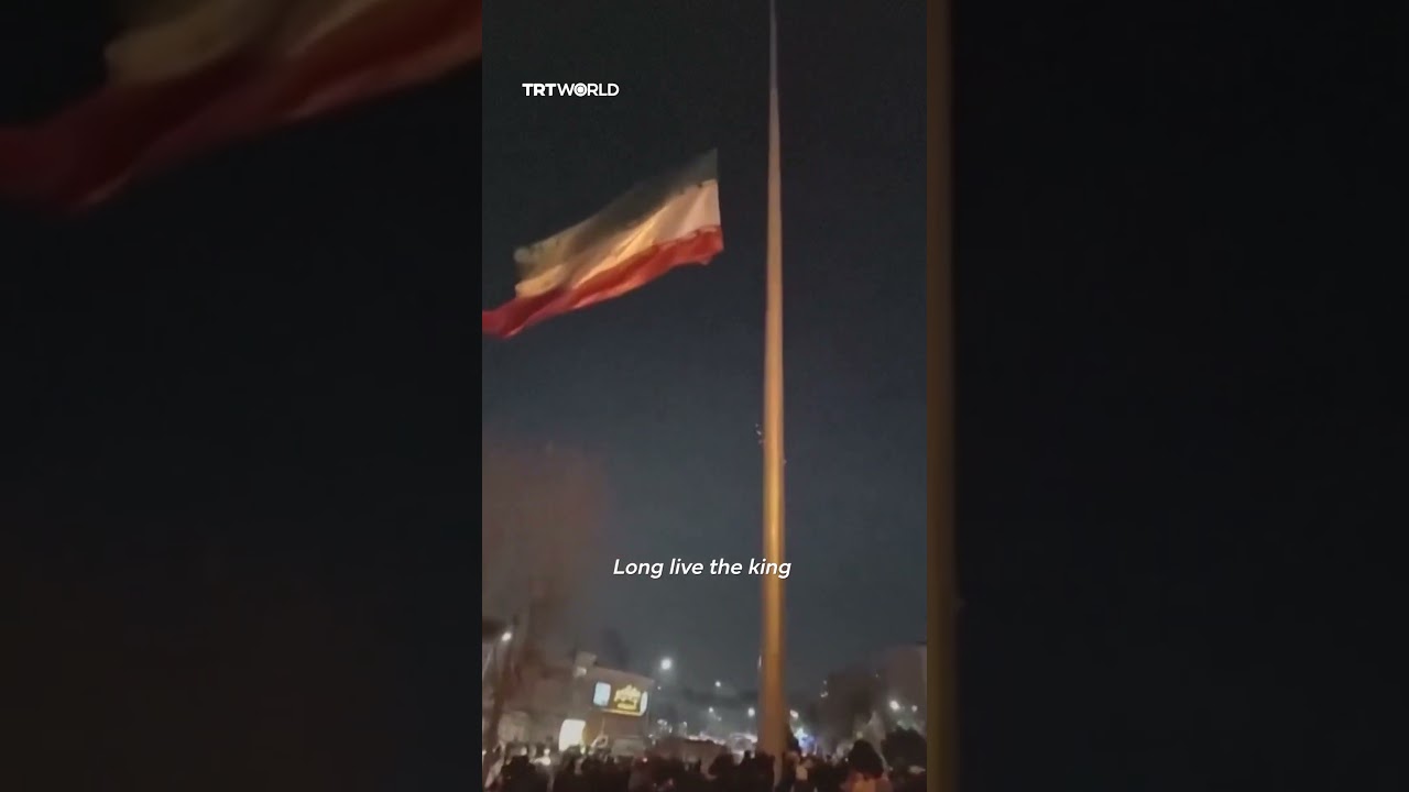 Protesters tear Iranian flag in half