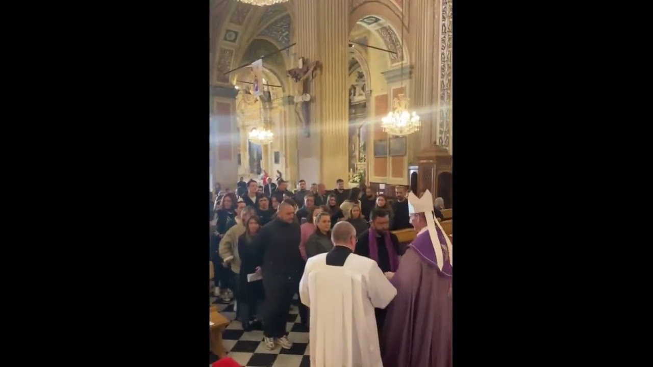 Bishop Fran&ccedil;ois Bustillo presents purple stoles to Catechumen ahead of their baptism on Easter
