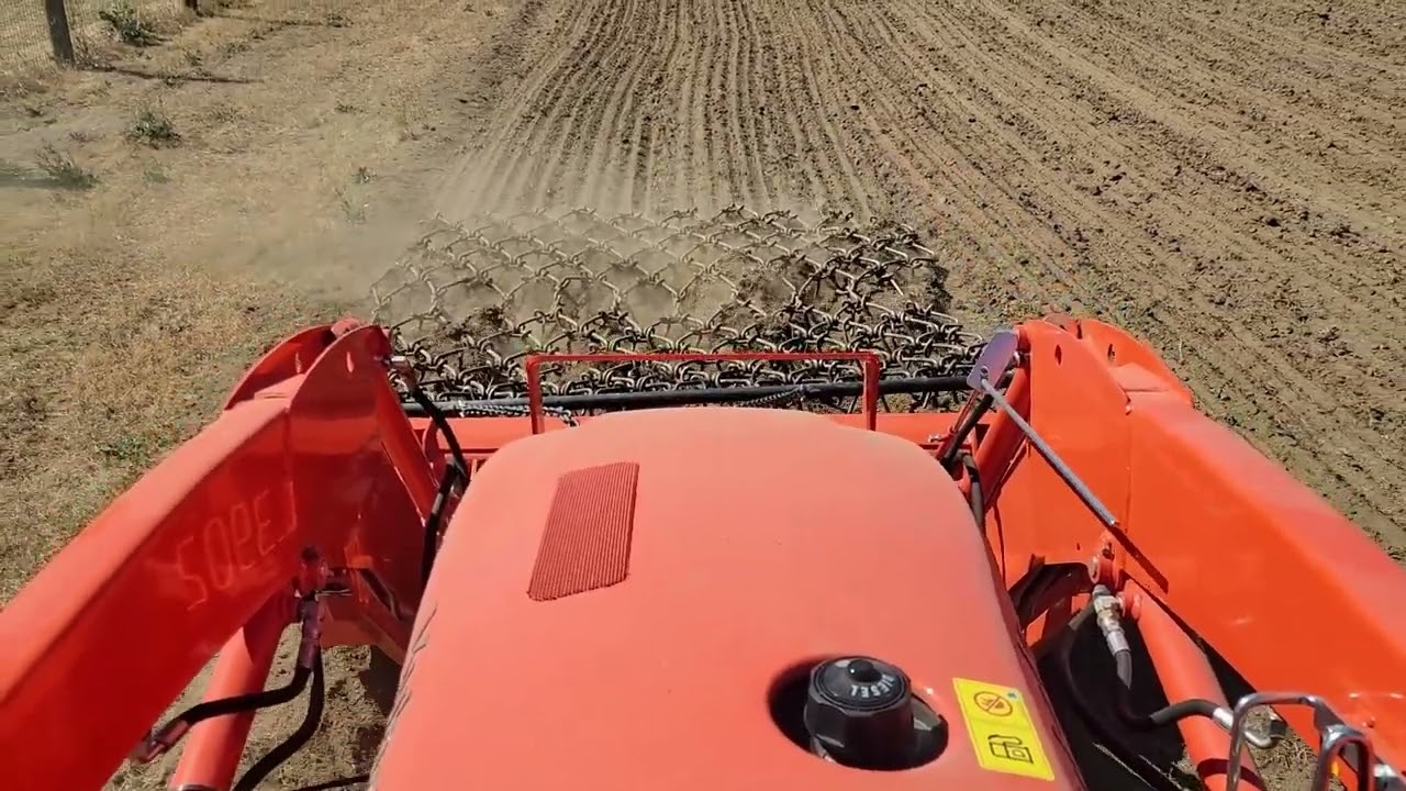 Using your front end loader to stay off pasture with a Tractor Supply chain harrow.