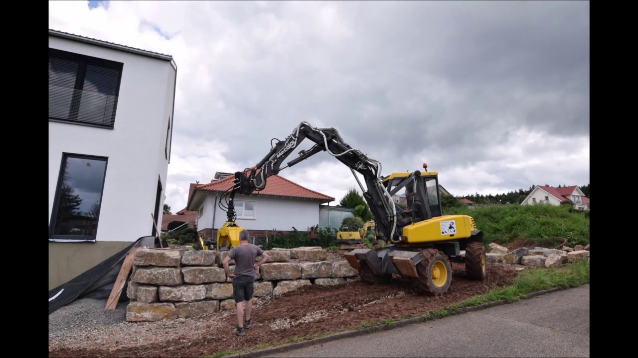 Natursteinmauer setzen mit Mecalac 12 MTX Bagger