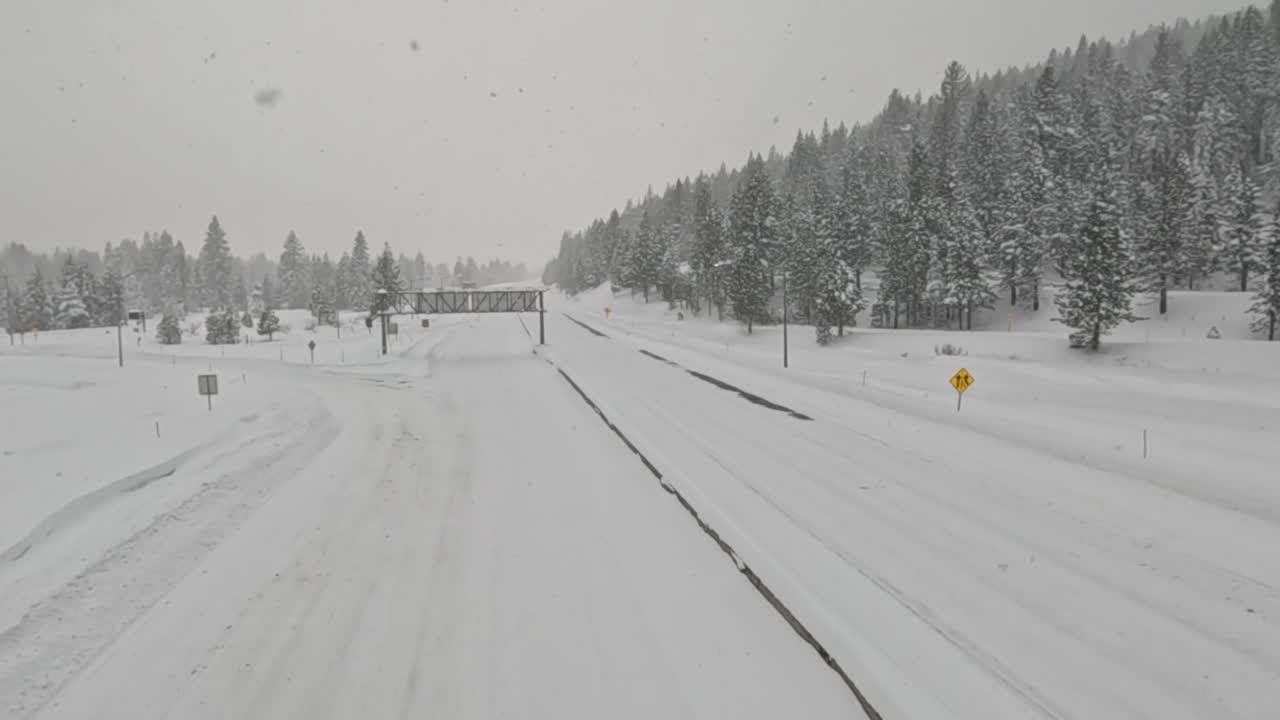 Snow falls on nearly deserted interstate in Truckee, California