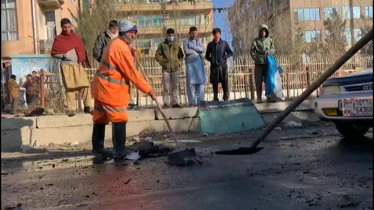 Men clean up street after deadly Kabul rocket attack | AFP