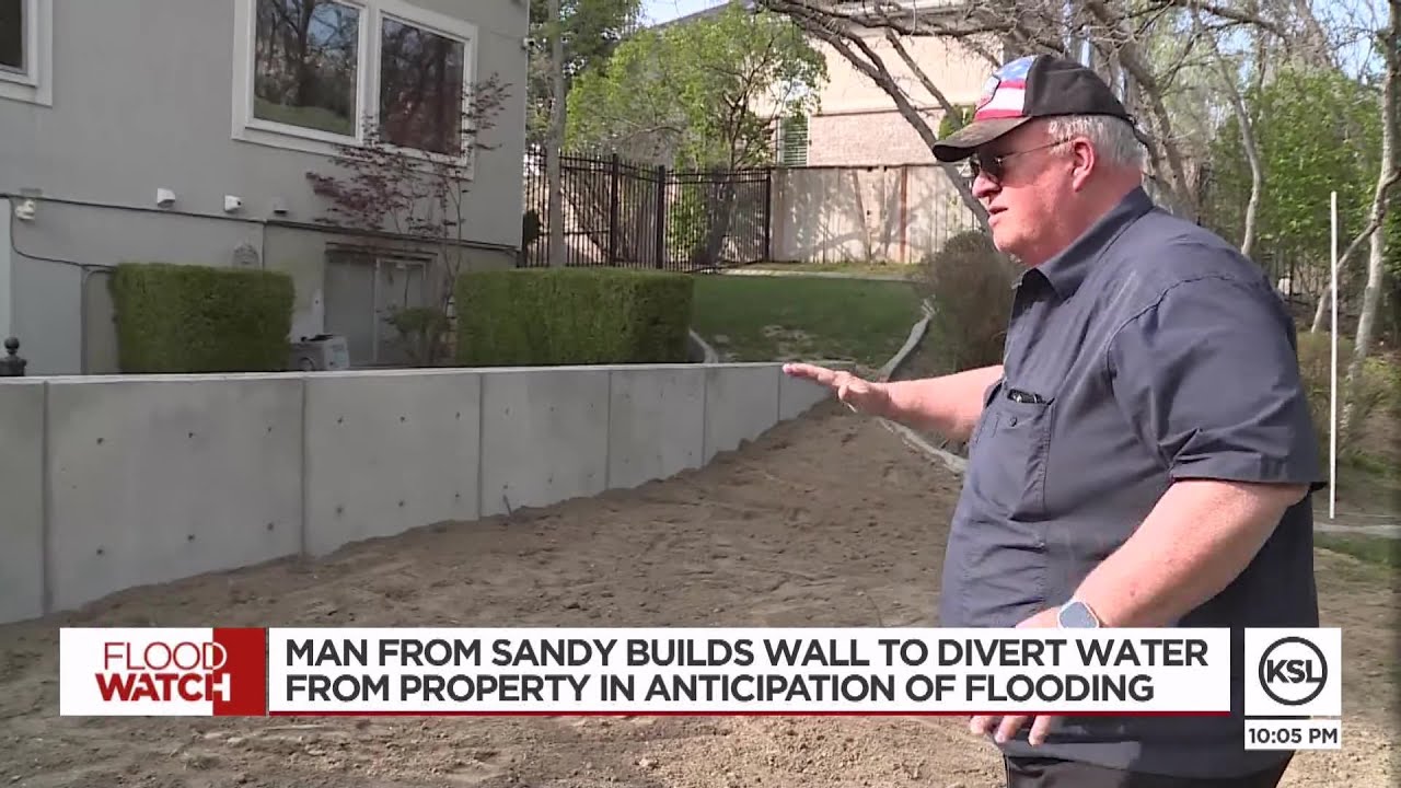 Sandy resident builds wall to divert water away from property in anticipation of flooding