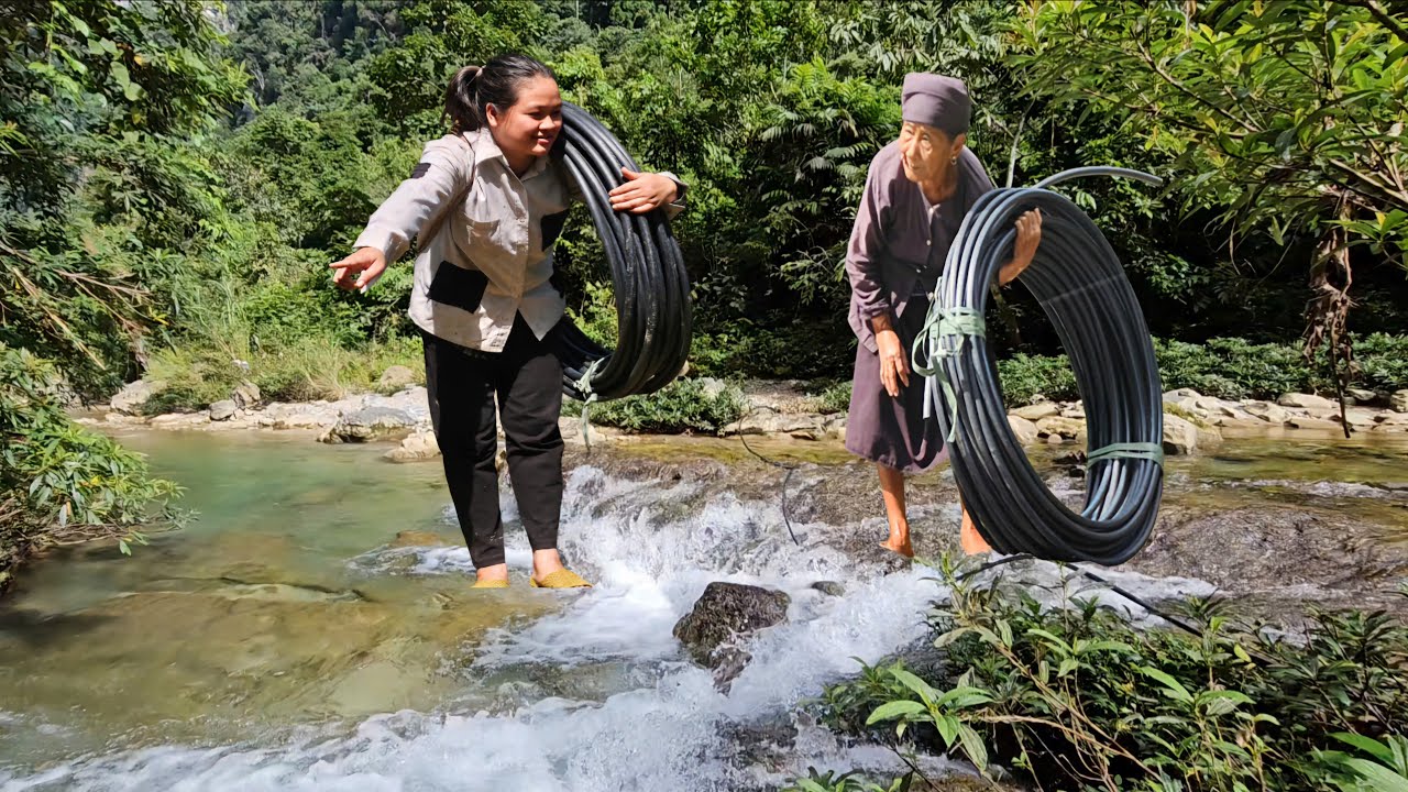 Poor old lady and homeless girl try to lead water pipe home before dark.