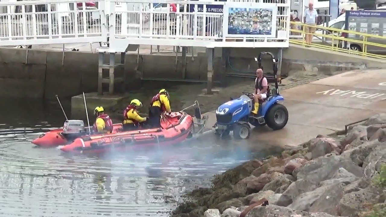 RNLI inshore lifeboat launching in Brixham Devon