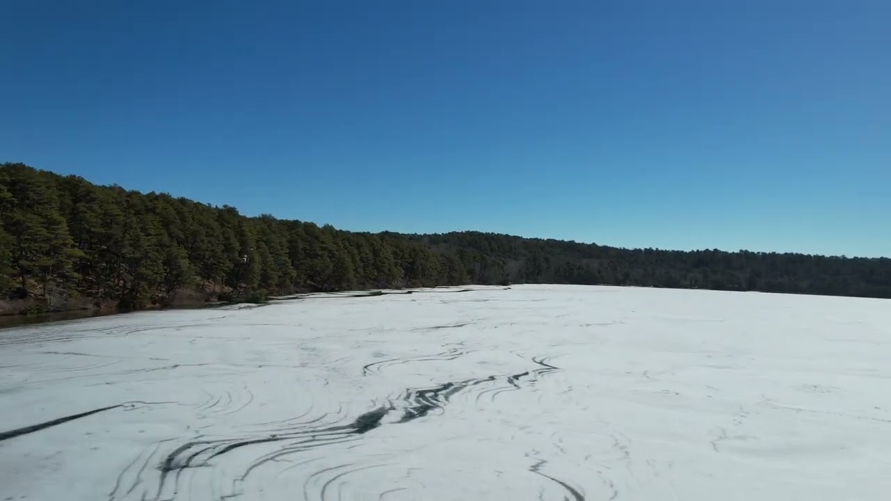Drone flight over melting ice on a Cape Cod kettle pond 