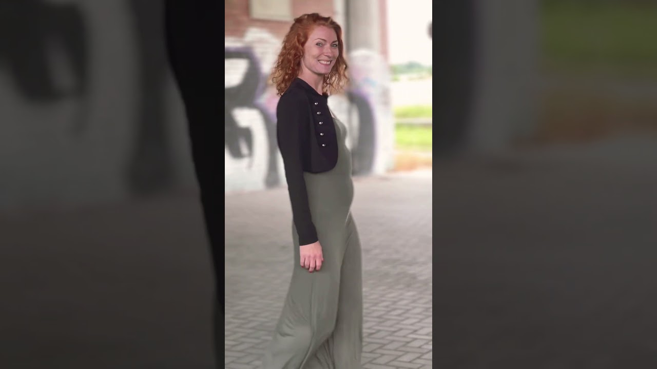 Rothaarige Dame im langen Kleid unter der Autobahn  