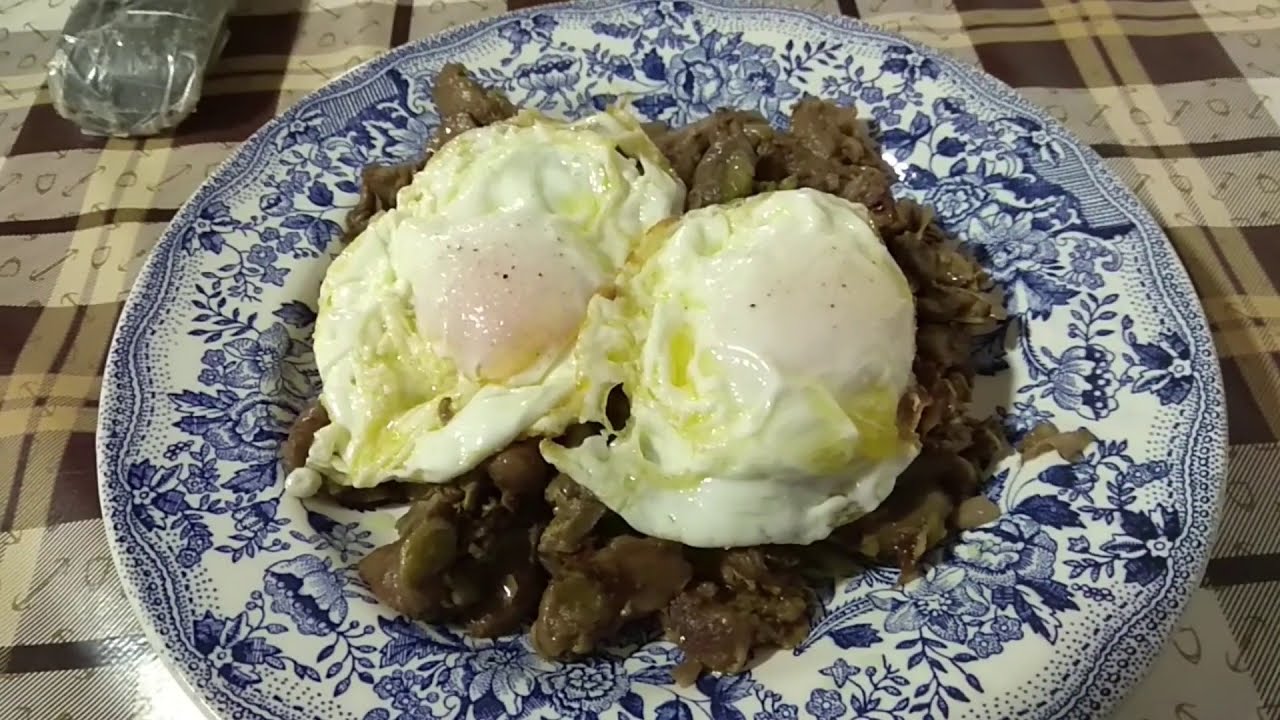 Habas con setas, jamón, cebolla y huevos fritos