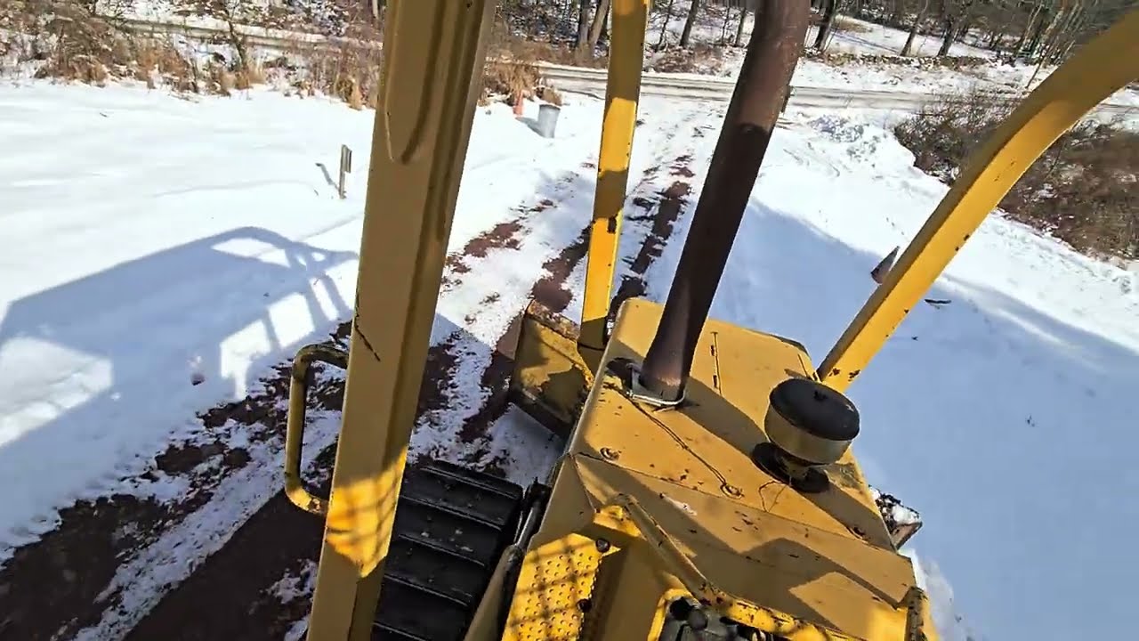 Plowing snow banks with the John Deere 450G Dozer.