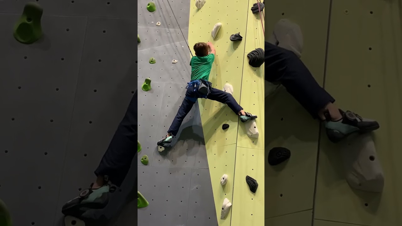 Kid rock climbing a route at the indoor climbing gym