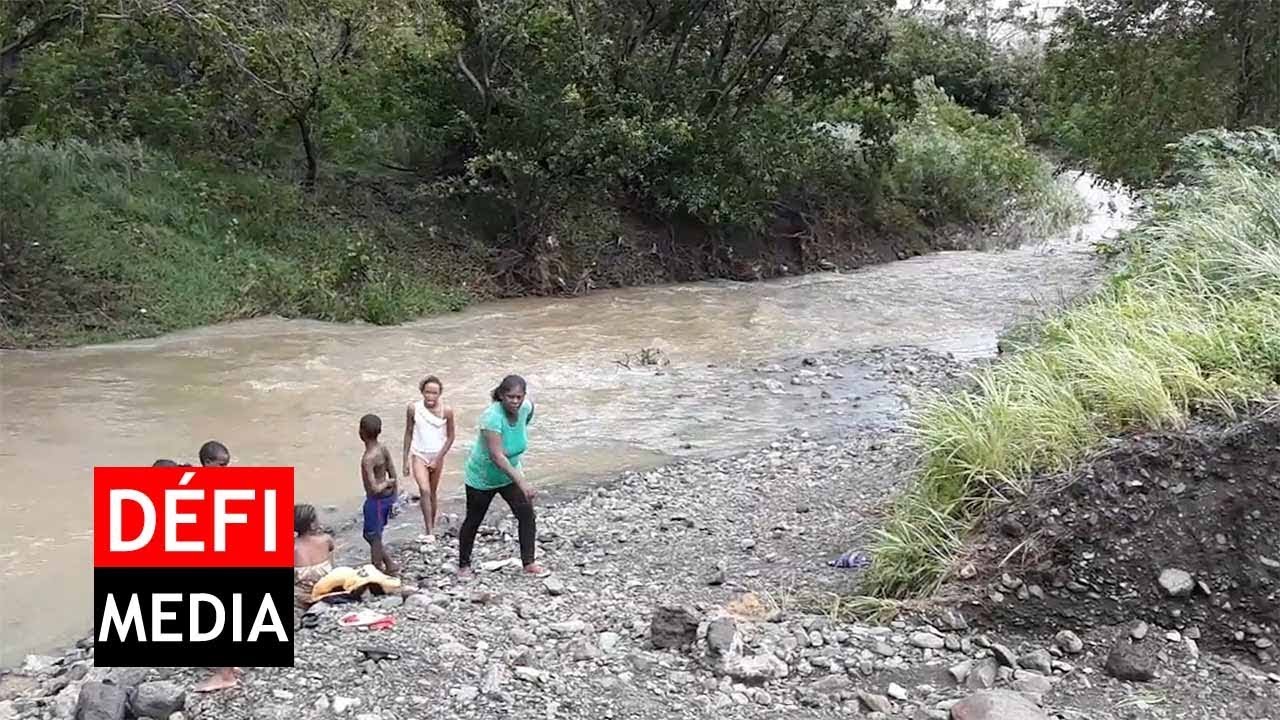 Une femme et six enfants pêchent à Cité La Cure, malgré la montée des eaux