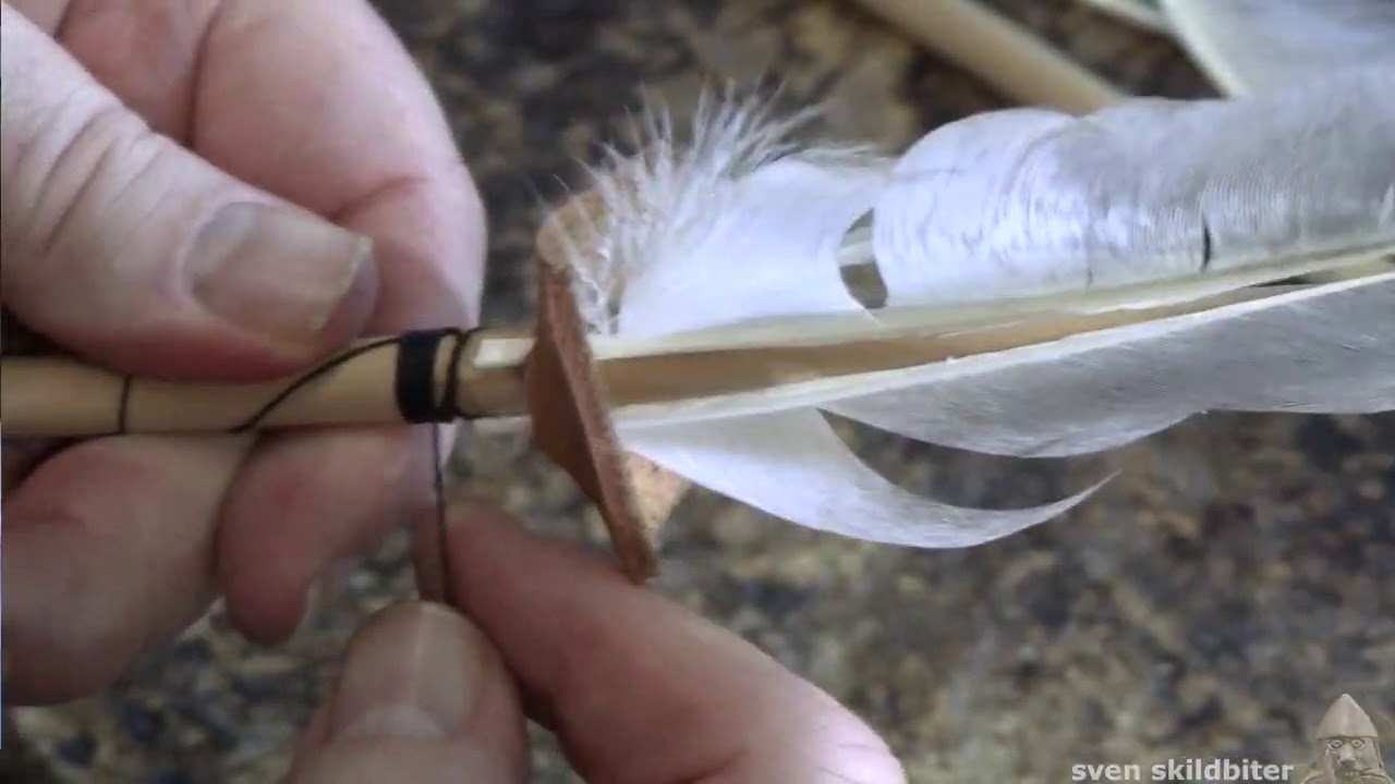 Fletching - Binding feathers to an arrow shaft using a leather jig.