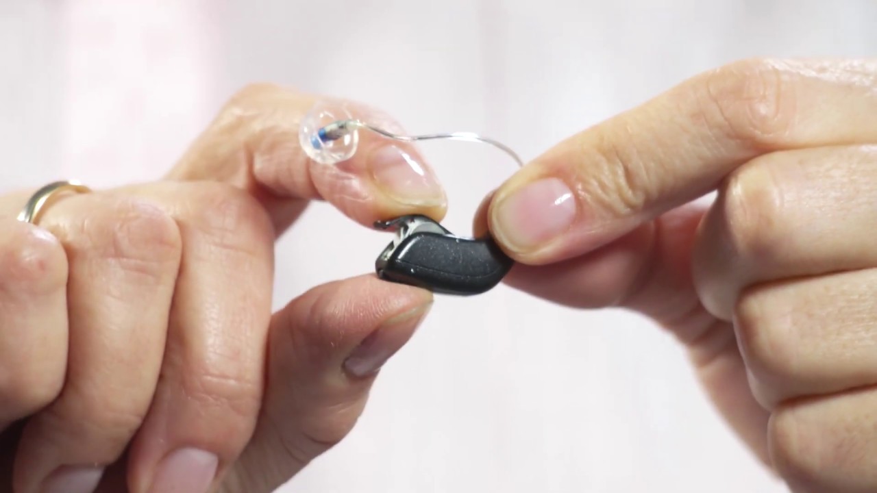 How to place the Oticon hearing aid with dome on the ear