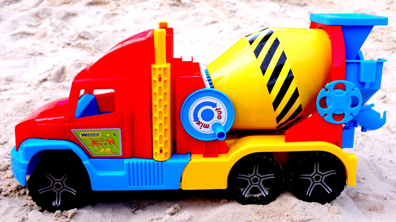 Speelgoedvrachtwagens in zand. Een betonmixer voor kinderen. Auto's en vrachtwagens voor kinderen.