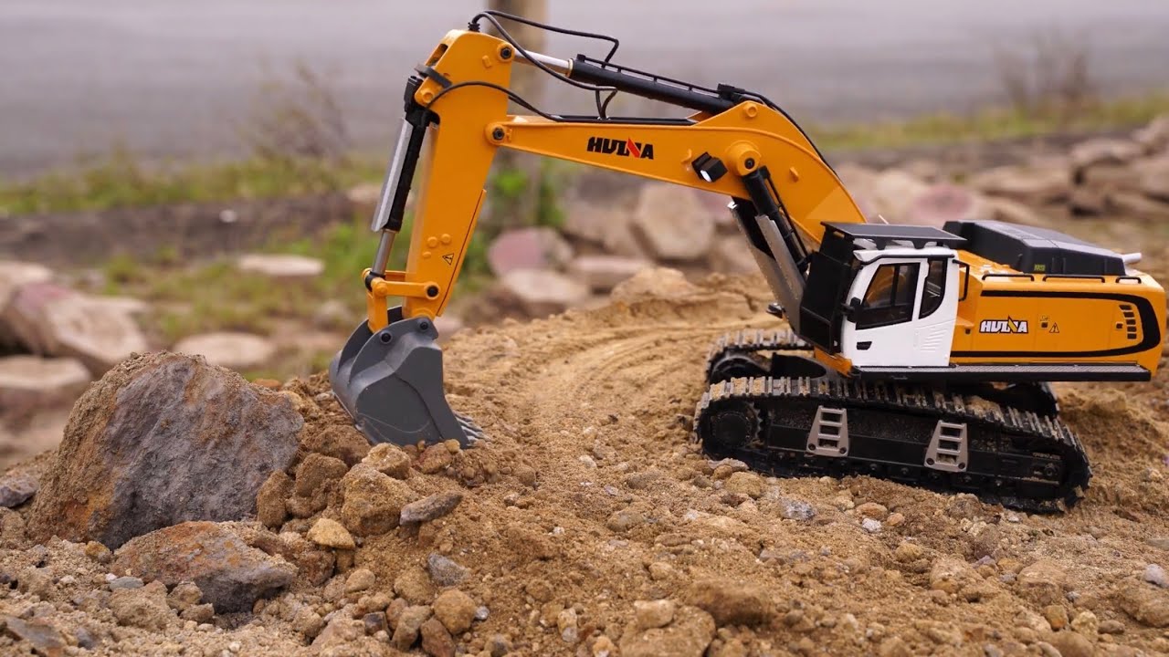 Excavators Huina 1599 scoop soil to create a space for dump trucks to park