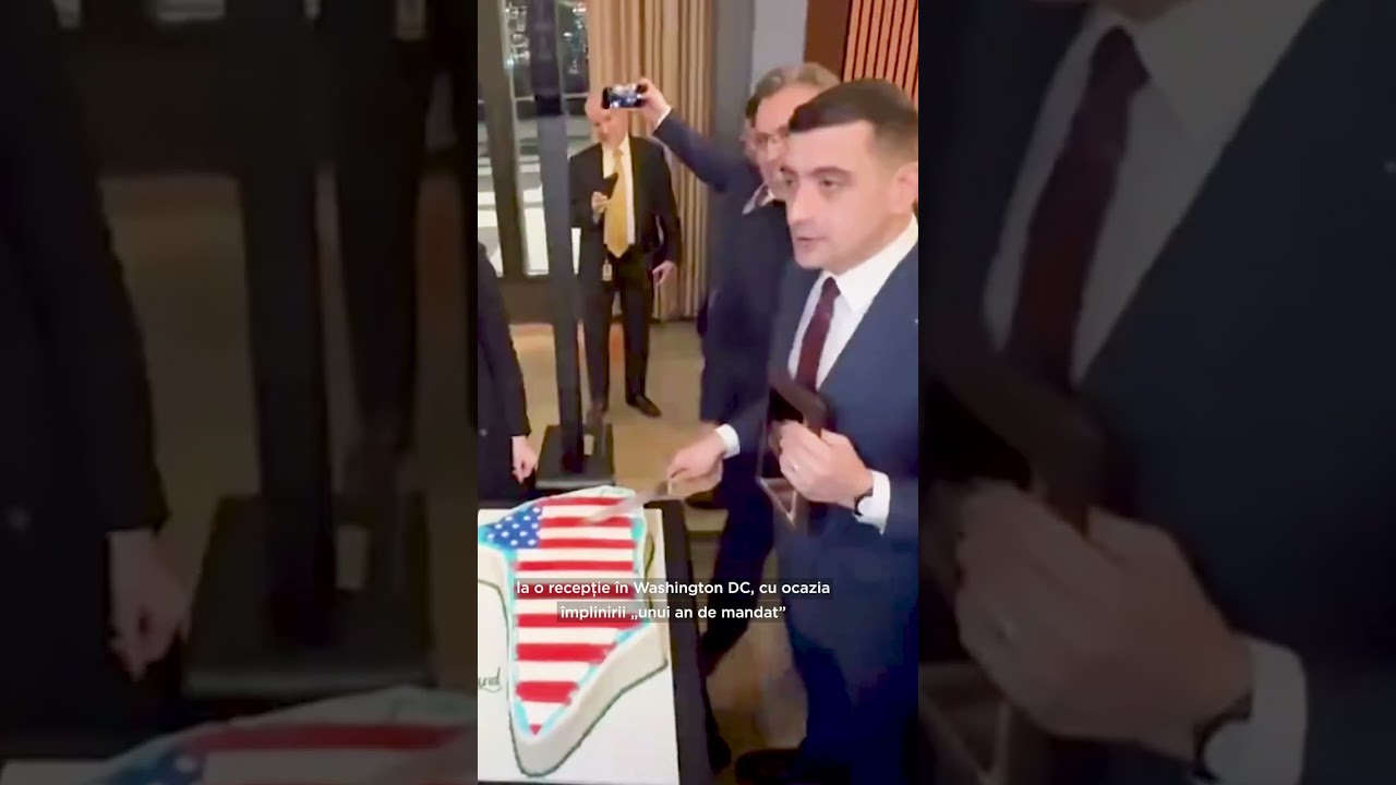 George Simion taie un tort &icirc;n formă de Groenlanda, decorat cu steagul american
