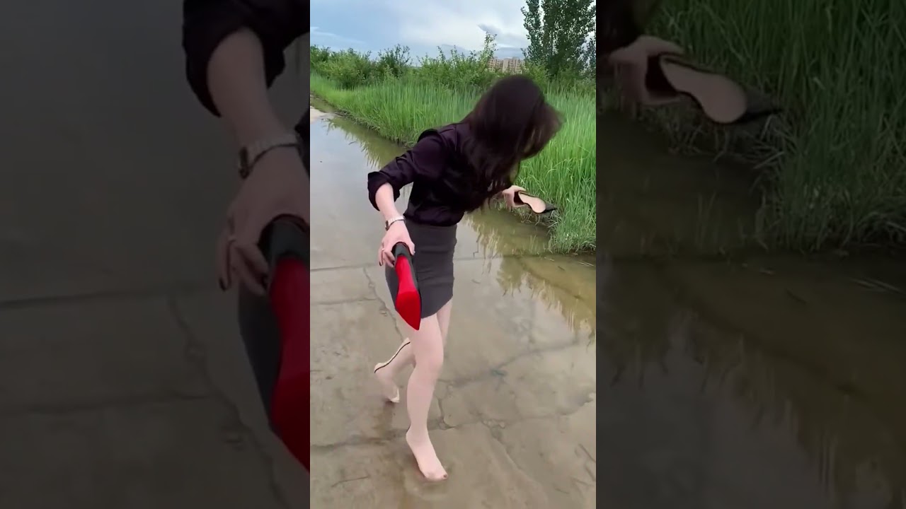 The woman takes off her louboutins and walks barefoot in the puddles 