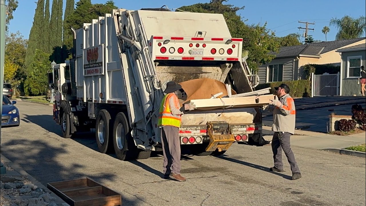Rear Load Garbage Truck Crushing Bulky Items (Universal Waste Systems) 