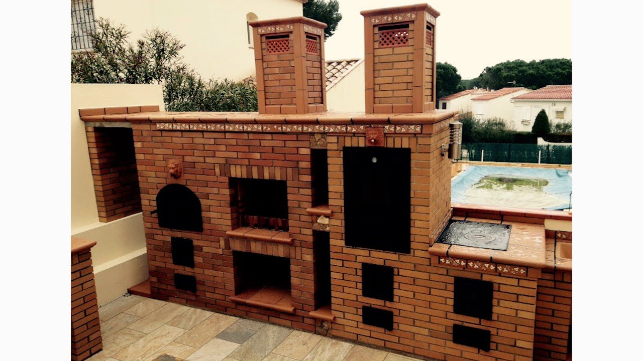 Cocina exterior completa con hornos y barbacoa.